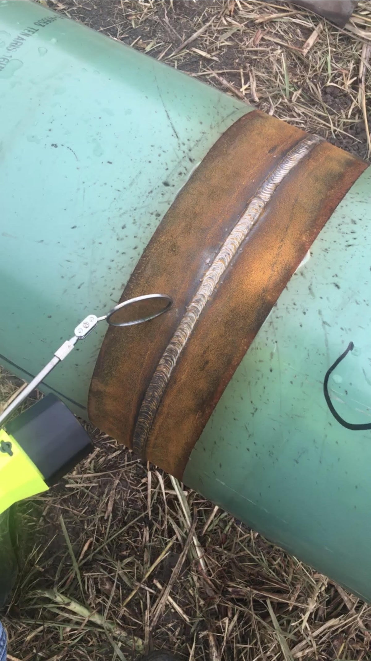 Inspector checking a pipeline girth weld with a mirror